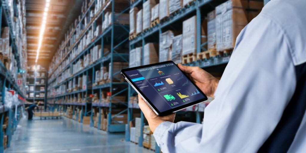 Gestión inteligente de inventarios mediante análisis predictivo Coordinador de almacén revisando dashboard de inventario con análisis predictivo en tiempo real.