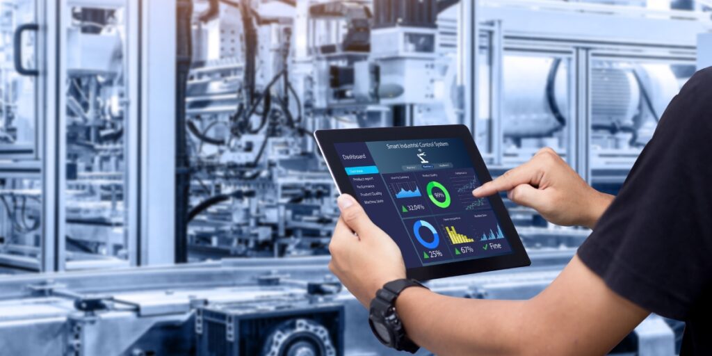 Líder de mantenimiento revisa un dashboard con KPIs clave—MTTR, disponibilidad y backlog—en una tablet frente a la línea de producción.